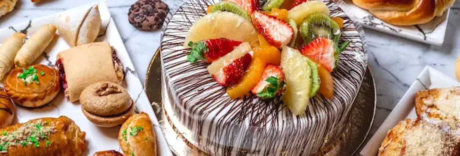 side-view-fruit-cake-with-vanilla-cream-chocolate-kiwi-orange-strawberry-pineapple-pastries-table_141793-4924